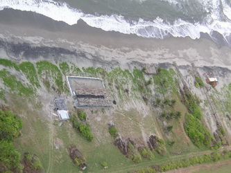 The disposition of the vegetation in this picture indicates the direction and extent of tsunami inundation. The presence of this construction in the tsunami inundation area indicates that this is in fact an area where no tidal or surf inundation takes place confirming the tsunami origin of the runup.